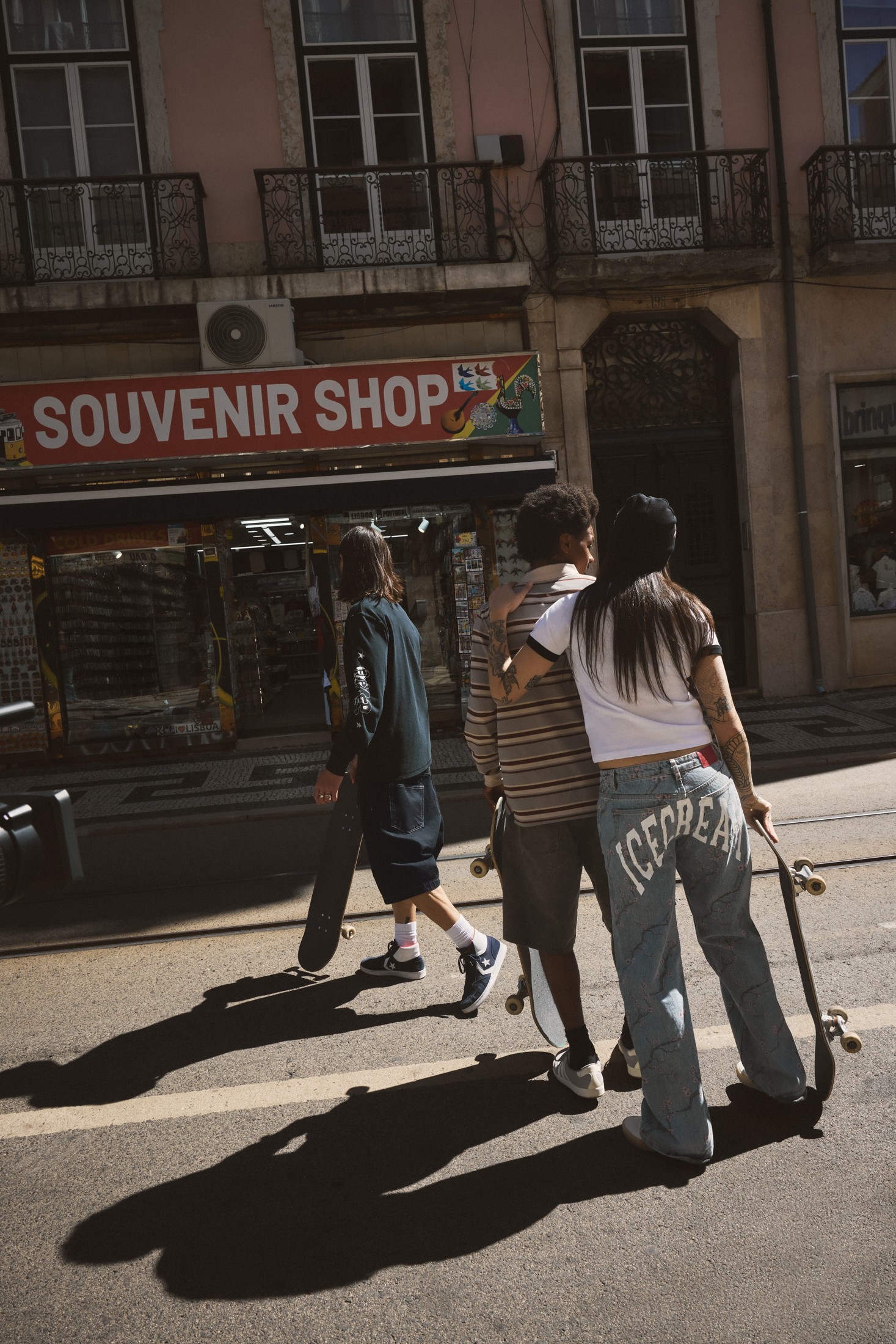 Three skaters on a sunlit Lisbon street